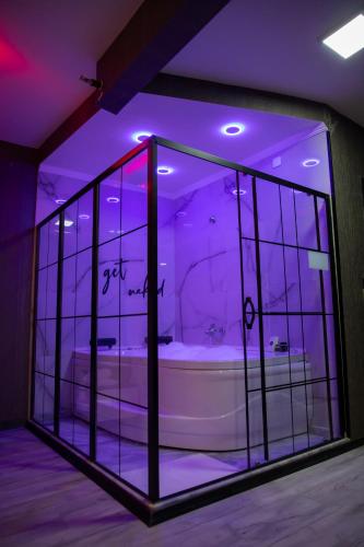 a bathroom with a tub in a room with purple lights at Hera Suit Ataşehir in Istanbul