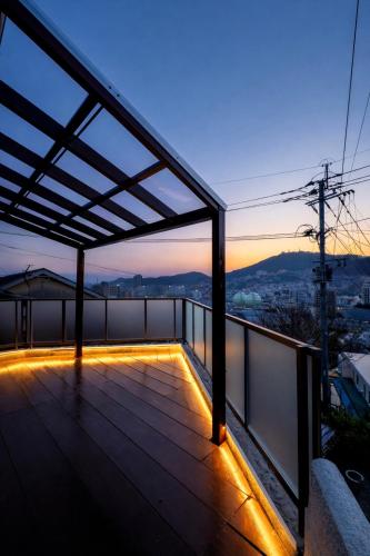 a roof deck with a view of the city at Inasa Worlds Top Night View Retreat稲佐パノラマ夜景1棟貸切 in Nagasaki
