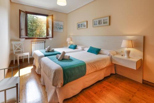 a bedroom with two beds and a window at LOPENEA Baztan in Garzáin