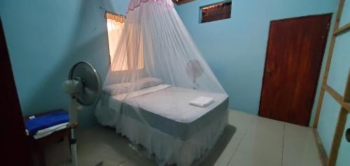 a bedroom with a bed with a mosquito net at Calala House in Balgue