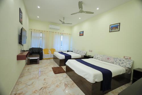 a hotel room with two beds and a couch at LK.Lodge in Kanyakumari