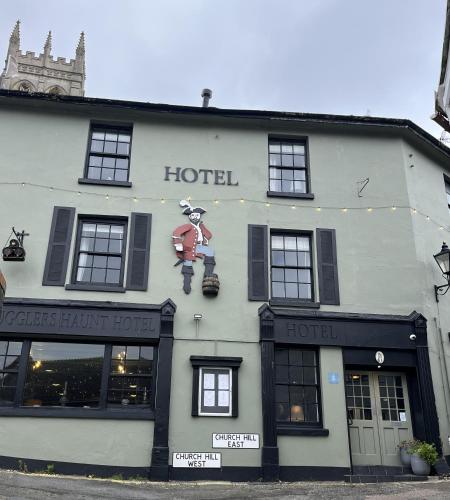 a hotel with a sign on the side of a building at Smugglers Hotel in Brixham