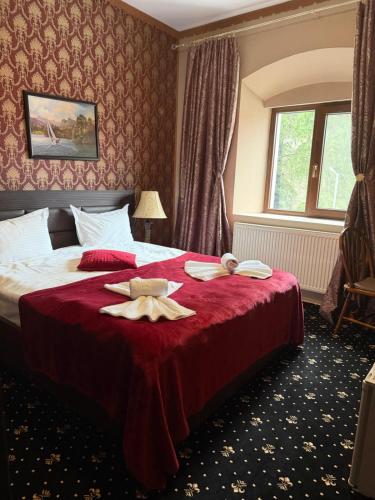 a hotel room with a bed with towels on it at Platinvm B&B in Predeal