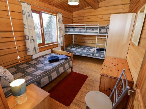 a room with two bunk beds in a cabin at Primrose Lodge in Evesham