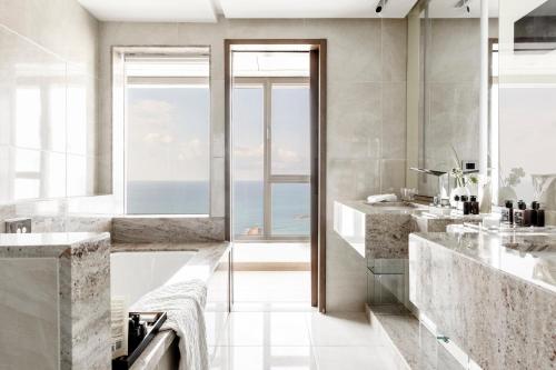 a bathroom with two sinks and a large window at InterContinental David Tel Aviv by IHG in Tel Aviv