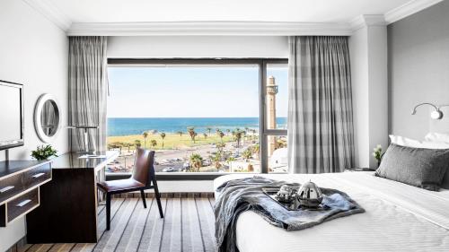 a bedroom with a large window with a view of a beach at InterContinental David Tel Aviv by IHG in Tel Aviv