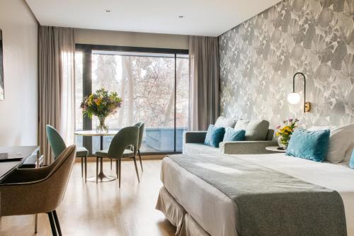 a hotel room with a bed and a table at Apartosuites Jardines de Sabatini in Madrid