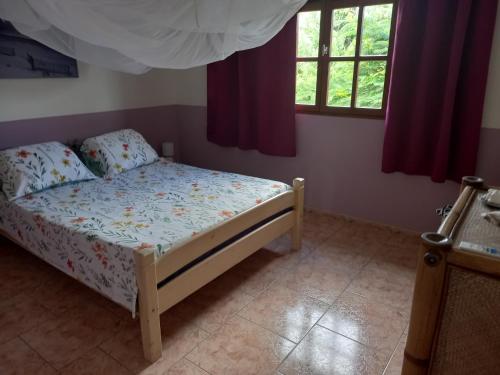 a small bedroom with a bed and a window at Appartement spacieux étage maison avec jardin à Ste Anne in Sainte-Anne