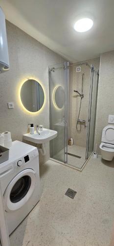 a bathroom with a shower and a washing machine at Apartments Grgurević in Kotor