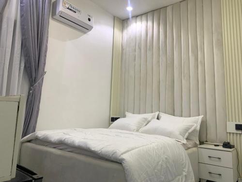 a bedroom with a bed and a air conditioner on the wall at Ehi-Mega Luxury Hotel and Apartment in Abuja