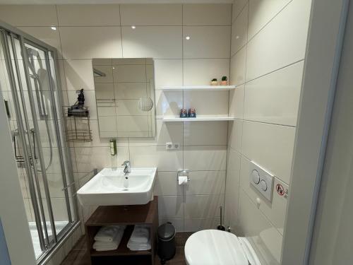 a white bathroom with a sink and a toilet at CityApartment K1 KLIMATISIERT in Friedrichshafen