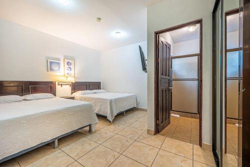 a bedroom with two beds and a sliding glass door at Garza 912 in Carpintero