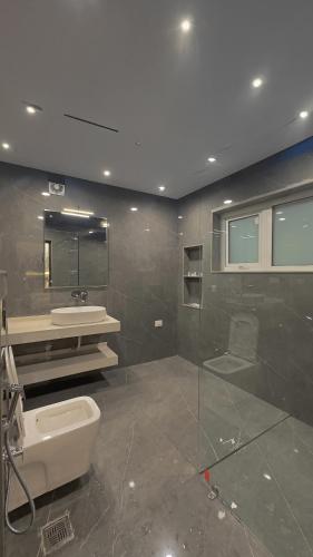 a bathroom with a toilet and a sink and a mirror at The Royal Luxe in Kolur