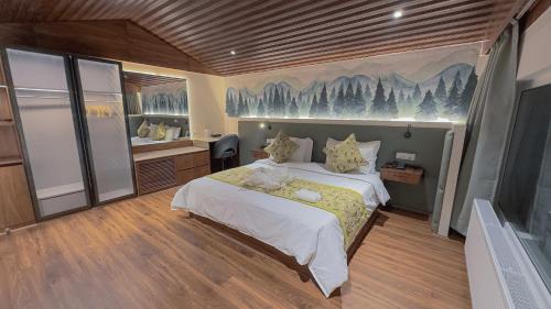 a bedroom with a bed with a painting on the wall at The Royal Luxe in Kolur