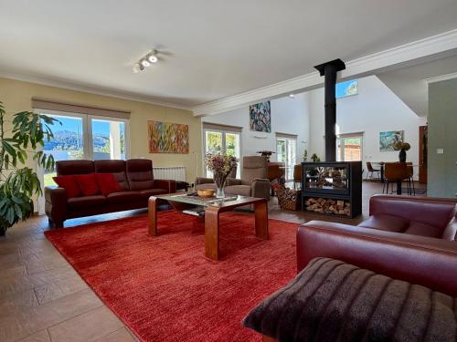 a living room with couches and a table and a fireplace at Casa Carvalhal - Adults Only in Góis