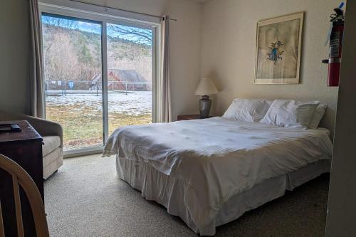 a bedroom with a bed and a large window at Seasons 103 in Warren