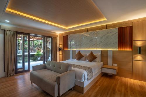 a hotel room with a bed and a couch at Aksara Ubud in Ubud