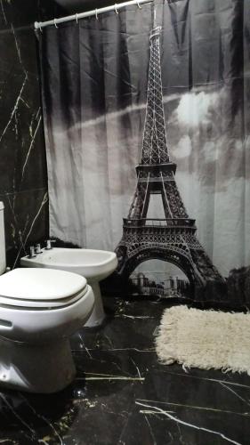 a bathroom with a toilet and the eiffel tower at Los del Sur cabañas in Comodoro Rivadavia