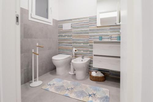 a bathroom with a toilet and a sink at Riflessi D'aurora in Castelsardo