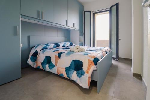 a bedroom with a bed with a colorful comforter at Riflessi D'aurora in Castelsardo