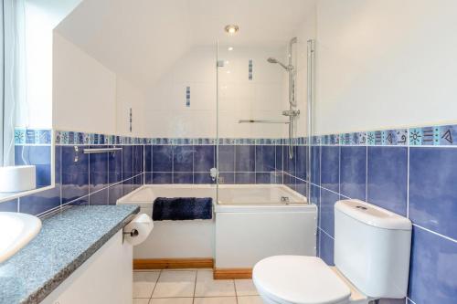 a bathroom with a tub and a toilet and a sink at 4 Bed in Croyde oc-sundow in Croyde