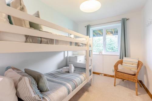 a bedroom with two bunk beds and a chair at 4 Bed in Croyde oc-sundow in Croyde