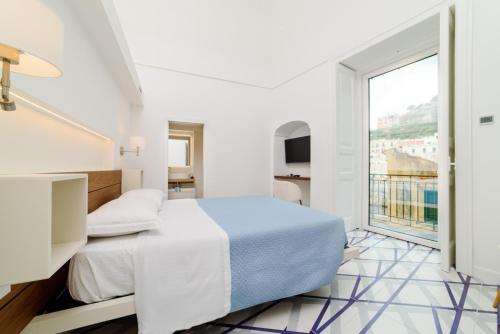 a bedroom with a bed and a large window at Palazzo Colavolpe in Atrani