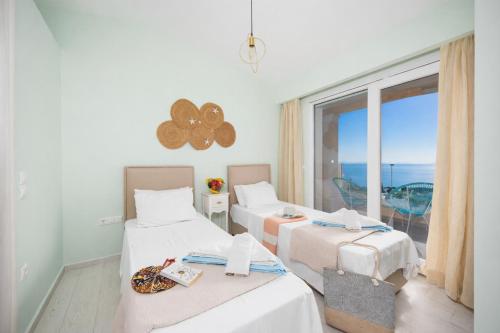 two beds in a room with a view of the ocean at Villa Damian in Barbati