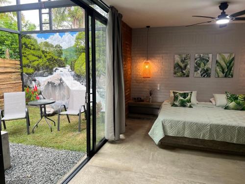 a bedroom with a bed and a large sliding glass door at Cabaña El Anhelo Bosque in Ginebra