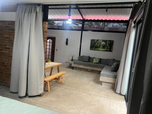 a living room with white curtains and a couch at Cabaña El Anhelo Bosque in Ginebra