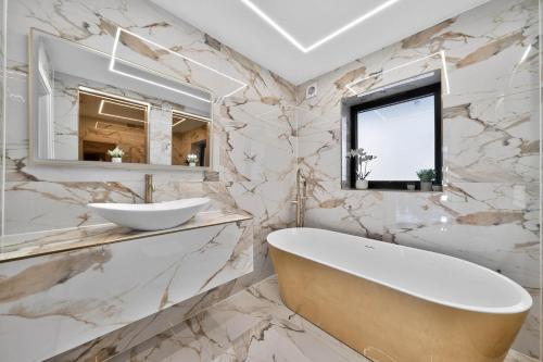 a white bathroom with a tub and a sink at Heddfan in Carmarthen