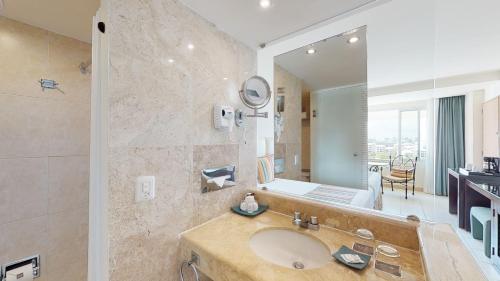a bathroom with a sink and a large mirror at Grand Oasis Palm - All inclusive in Cancún