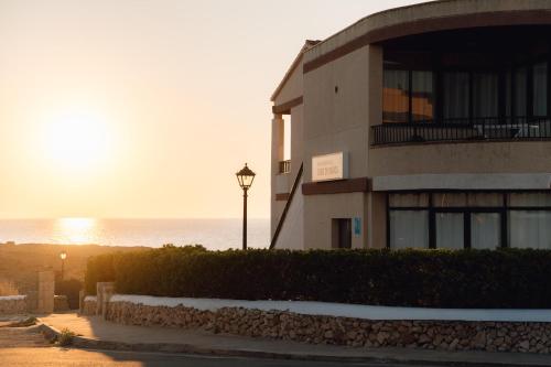 a building with a street light in front of the ocean at BLUESEA Cabo de Baños in Cala en Blanes