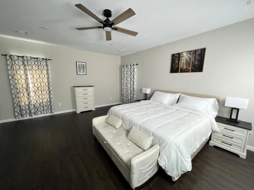 a bedroom with a white bed and a ceiling fan at South Robins Retreat in Warner Robins