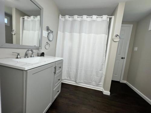 a white bathroom with a sink and a shower at South Robins Retreat in Warner Robins
