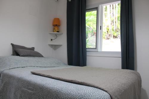 a bedroom with a bed and a window at Kaz Manga Rose in Deshaies