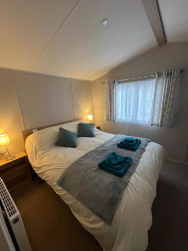 a bedroom with a large bed with blue towels on it at Tayock Park in Montrose