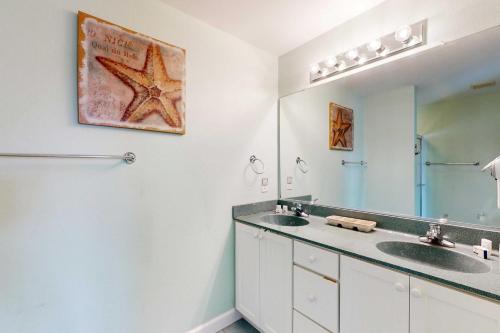a bathroom with two sinks and a large mirror at Buhlers Day Off in Corolla