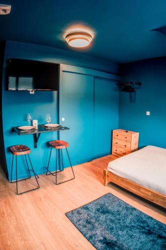 a bedroom with a bed and a table and stools at La Maison 12 in Valenciennes