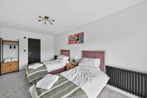 a bedroom with two beds and a ceiling fan at Ty Hir in Llanelli