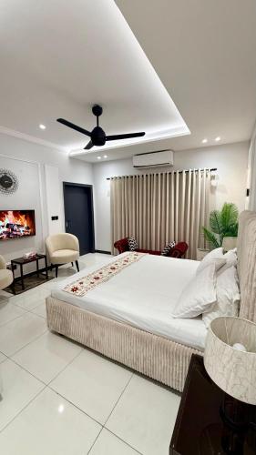 a bedroom with a large bed with a ceiling fan at Luxury Private Room Canal Rd Near Galleria in Faisalabad