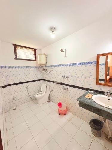 a bathroom with a toilet and a sink at New Suraj Inn - Nestled near Hadimba Temple ! Rooftop Cafe ! Private Parking in Manāli