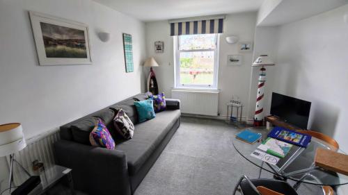 a living room with a couch and a window at One Fisherman's Loft in Brixham