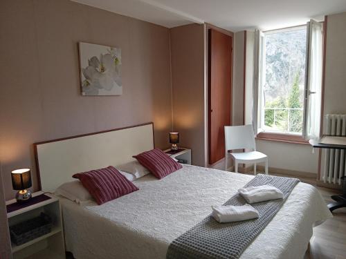 a bedroom with a bed with two pillows on it at Hôtel La Gravenne in Thueyts