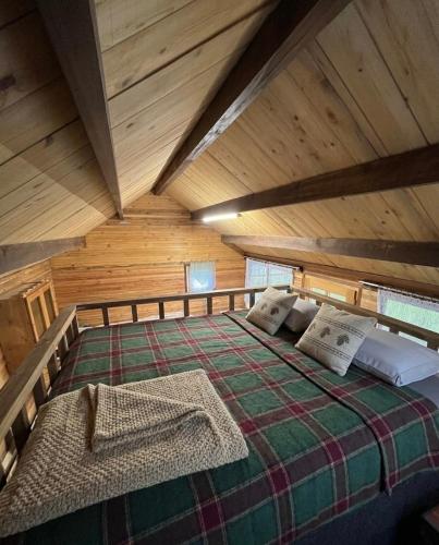 a large bed in a room with wooden ceilings at House by the river in Ptuj