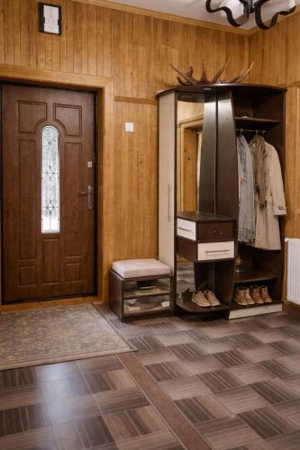 a room with a door and a closet with a refrigerator at Pid Skeleyu in Lazeshchyna