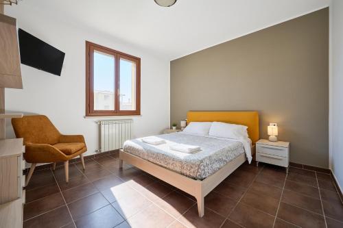 a bedroom with a bed and a chair at Casa La Polledraia in Venturina Terme