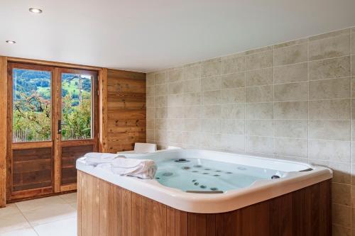 a large bath tub in a bathroom with a window at chalet in authentic Manigod farm in Manigod