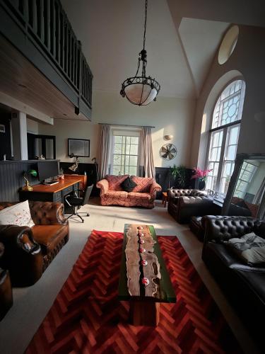 a living room with couches and a table at The Old Court House & Jail in Menai Bridge