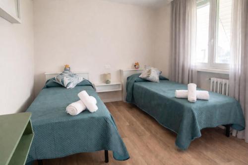 a bedroom with two beds with towels on them at Maison Louis in Parma